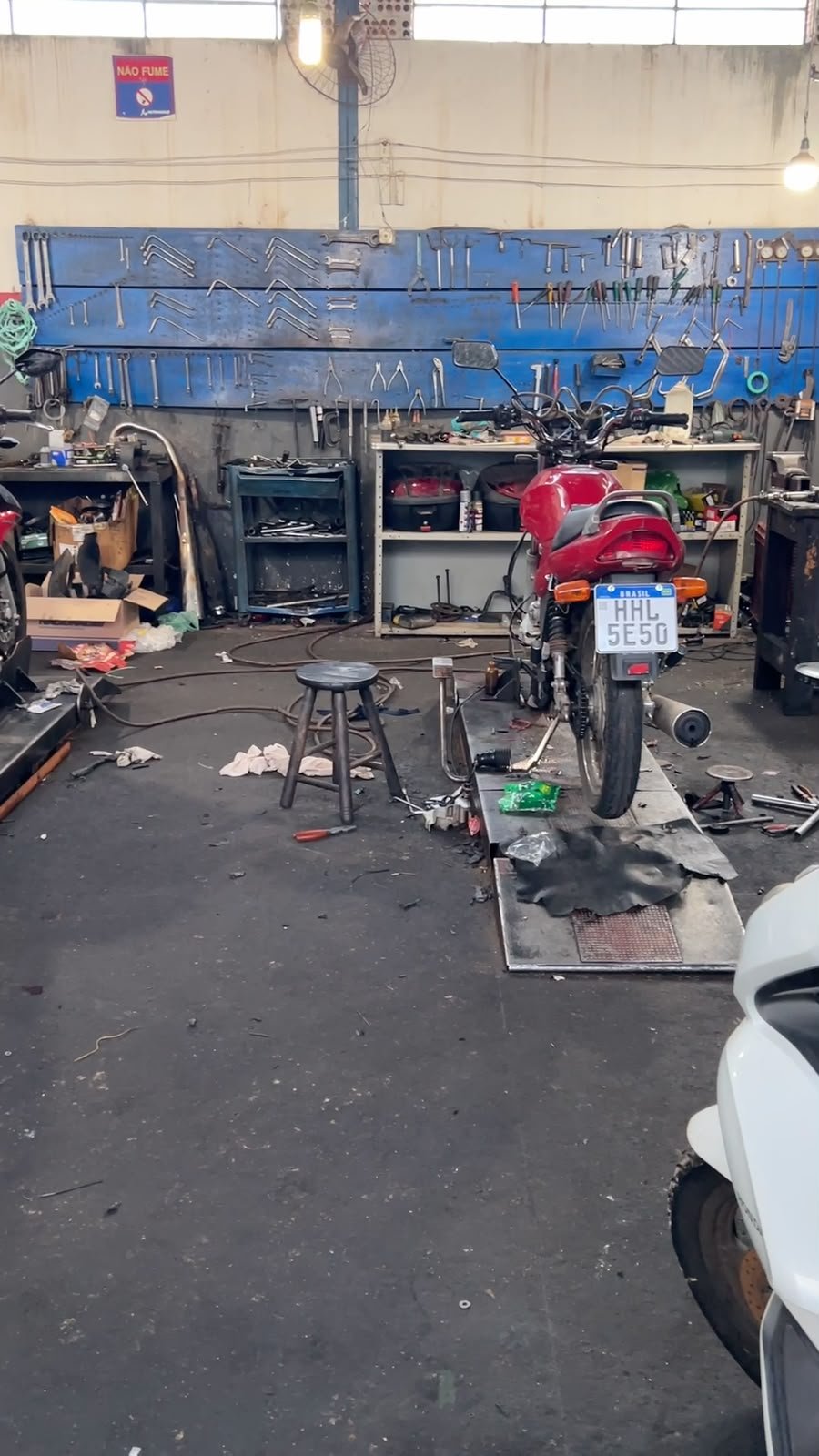 Bancada de ferramentas e moto no elevador da oficina MotoBlanco